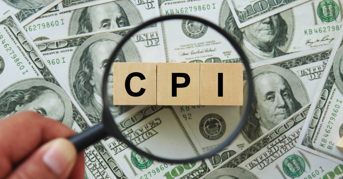 Three wood blocks that read "CPI" in front of hundred dollar bills are magnified by a hand holding a magnifying glass.